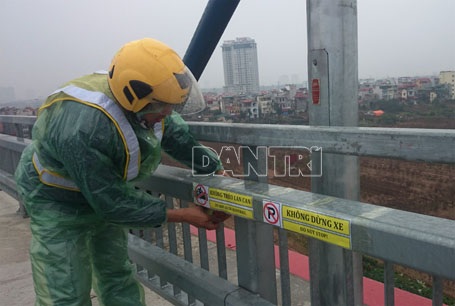 Nhân viên Ban quản lý cầu Nhật Tân đang dán biển cấm lên lan can cầu