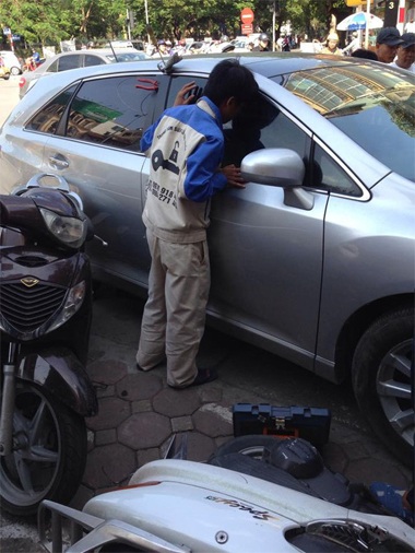 Hà Nội: Ô tô đâm loạn xạ trên phố, tài xế vẫn “ngủ ngon” - 2 Nhân viên cứu hộ đang tìm cách mở cửa xe đưa tài xế đang ngủ ngon trong xe