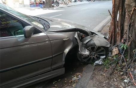 Hà Nội: Xe BMW gần rời bánh trước sau cú “đọ sức” với gốc đa - 2 Đầu xe bị hư hỏng nặng, 1 bánh trước gần rời hẳn khỏi xe