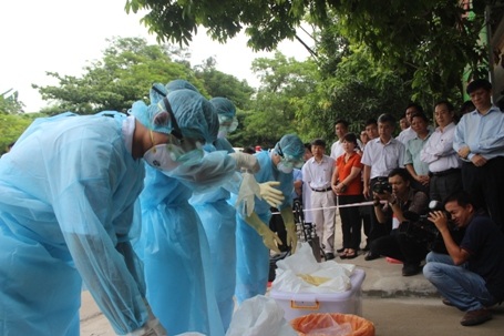 Nhân viên y tế đang mặc bảo hộ...