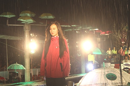 Các người ɭẫu mặc những chiếc áo mưa đi
dưới cơn mưa nhân tạo.