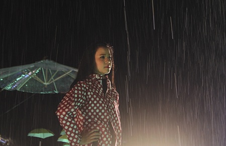 Các người mẫu mặc những chiếc áo mưa đi
dưới cơn mưa nhân ɴạo.