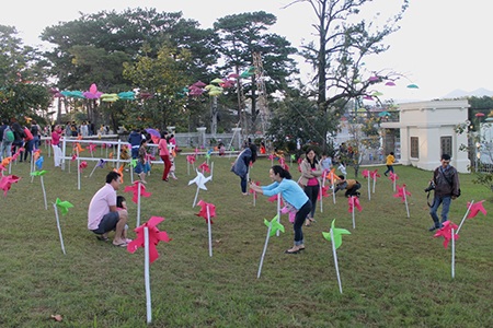 Du khách hứng thú chụp hình tại cánŨ đồng
chong chóng đầy màu sắc kế bên “con đường mưa”.
