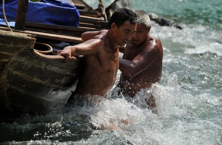 Đàn ông Trung Quốc... khỏa thân kéo thuyền chở khách đi vãn cảnh