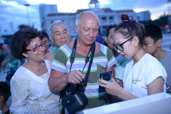 Một cặp vợ chồng nước ngoài thích thú khi được hòa mình vào không khí sôi động của ngày hội.