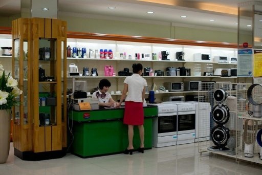 Người Triều Tiên tiêu tiền như thế nào? - 1 Các nhân viên đang đợi khách hàng tại một siêu thị tại Bình Nhưỡng ngày 28/7.