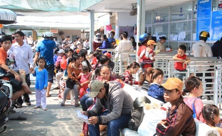 Cần Thơ: Bệnh viện đông nghẹt bệnh nhân sau nghỉ lễ - 1 Bệnh nhân ngồi phơi nắng, đợi đến lượt khám ở bệnh viện Nhi đồng Cần Thơ sáng 4/5