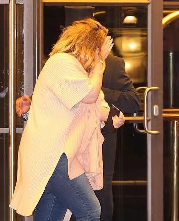 Adele giơ tay che mặt khi rời khách sạn Beumont