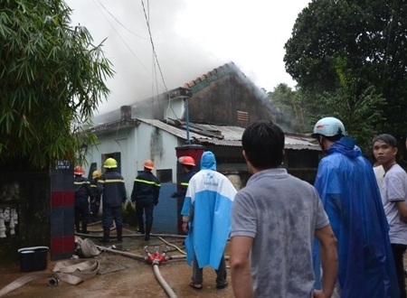 Người dân đội mưa xem lực lượng PCCC dập lửa.