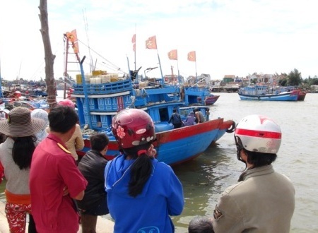 Người dân địa phương đón tàu cá đưa thi thể ngư dân Võ Duy Ánh về cập cảng Sa Kỳ.