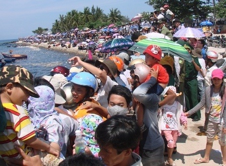 Hàng ngàn người chen nhau trên bờ kè xem đua thuyền.