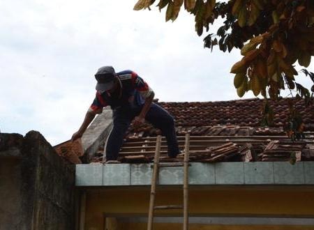 Người dân lớp lại mái ngói vừa bị lốc cuốn bay.