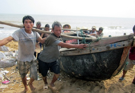 Người dân ven biển gánh tàu lên bờ vào sâu trong đất liền (Ảnh: Nguyễn Duy)