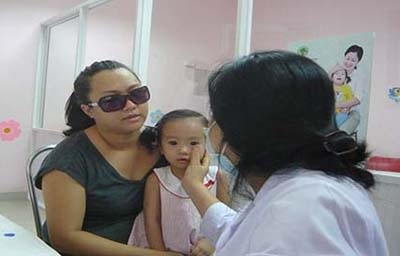 Xáo trộn cuộc sống vì dịch đau mắt đỏ - 1 Cả mẹ lẫn con đi khám vì đau mắt đỏ.