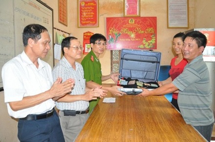 Đi tập thể dục phát phiện va li chứa nhiều tiền, vàng - 1 Trao trả tài sản cho gia đình anh Hoàng VĂn Hân - Ảnh do công an cung cấp