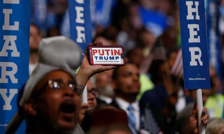 New York Times: Mỹ đang “hoảng” vì những bước đi của ông Putin - 2 Một cử tri Mỹ giơ lên biểu ngữ mang dòng chữ Putin và Trump khiến nước Nga hùng mạnh trở lại. (Ảnh: EPA)