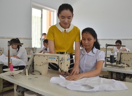 Cô giáo Võ Thị Thanh Hương ân cần hướng dẫn trẻ khuyết tật may đồ công nghiệp.