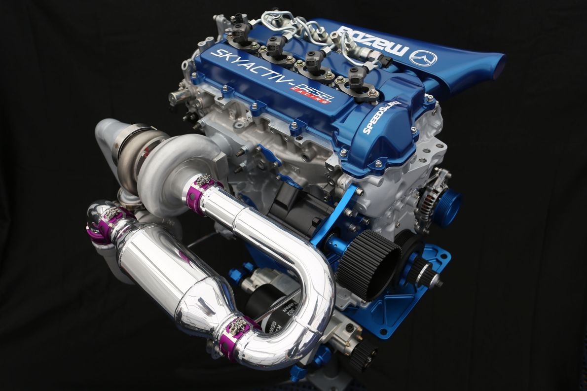 Mazda liều mình đưa động cơ diesel tới Mỹ - 2
Động cơ SkyActiv-D, theo Mazda, có tỉ số nén khá thấp (14:1), giúp tăng hiệu suất nhiên liệu, hệ thống tăng áp được xử lí tốt hiện tượng trễ ở vòng tua thấp. Ngoài ra, động cơ này còn có khả năng đạt momen xoắn cực đại ở vòng tua động cơ lên tới 5.200 vòng/phút và đáp ứng tiêu chuẩn khí thải Euro 6
