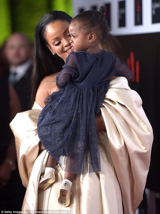 Rihanna gợi cảm với “vòng một” căng đầy - 7
Rihanna cưng nựng cô cháu gái 18 tháng tuổi trên thảm đỏ của sự kiện.