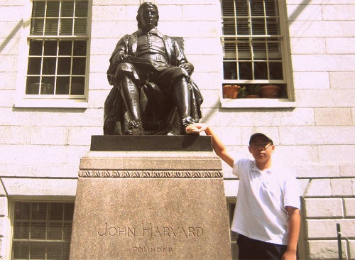 Hoàng Minh Tuệ bên tượng đài John Harvard tại Đại học Harvard (bang Massachusetts, Mỹ) trong chuyến du học bổng ASSIST năm 2013.