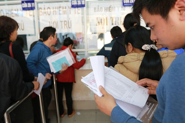 Tự chủ tài chính: Bệnh viện lo nợ, bệnh nhân lo bị “tận thu” - 1 Người nhà bệnh nhân xếp hàng ở cửa thu tiền của BV Việt Đức. Ảnh: Hải Nguyễn