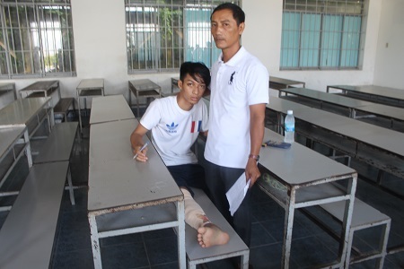 
Chân bị gãy, đang bó bột trắng toát, đau nhức… nhưng thí sinh Nguyễn Thành Chung, dự thi THPT quốc gia tại điểm thi ĐH Nha Trang vẫn đến trường thi. Trong ảnh: Hai cha con em Chung trong phòng thi sáng 1/7. (Ảnh: Viết Hảo)
