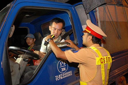 Từ hôm nay, phạt đến 18 triệu đồng tài xế có hơi men - 1 CSGT kiểm tra nồng độ cồn của các tài xế tại TPHCM. (Ảnh: Trung Kiên)