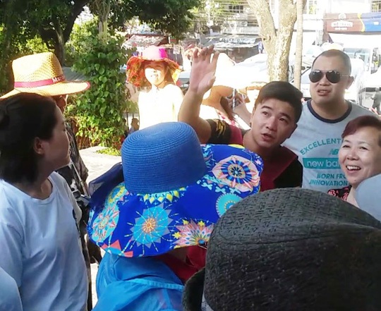 Người Trung Quốc và thế giới ngầm du lịch - 1 Một người Trung Quốc (giơ tay) từ xe của Công ty Silent Bay bước xuống, giới thiệu cho khách Trung Quốc tham quan tại Tháp Bà (TP Nha Trang) Ảnh: KỲ NAM