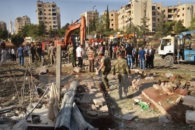 Liên quân tiêu diệt 30 phần tử IS, đánh bom kinh hoàng ở Damascus - 1 Lực lượng an ninh Syria làm việc sau một vụ ném bom. (Ảnh: AFP/TTXVN)