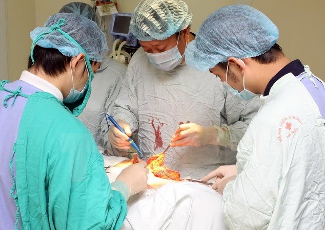 Hà Nội xét tuyển đặc cách bác sỹ nội trú và thủ khoa xuất sắc - 1 Các bác sỹ Bệnh viện Ung Bướu Hà Nội thực hiện một ca phẫu thuật. (Ảnh: Dương Ngọc/TTXVN)