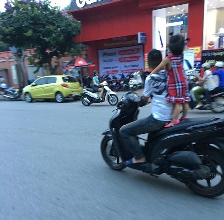 Ông bố chở con "liều mạng" trên đường gây bức xúc - 2 Hành động diễn xiếc trên đường Kim Mã (Hà Nội) khiến nhiều người ái ngại. Ảnh: Diễn đàn OF