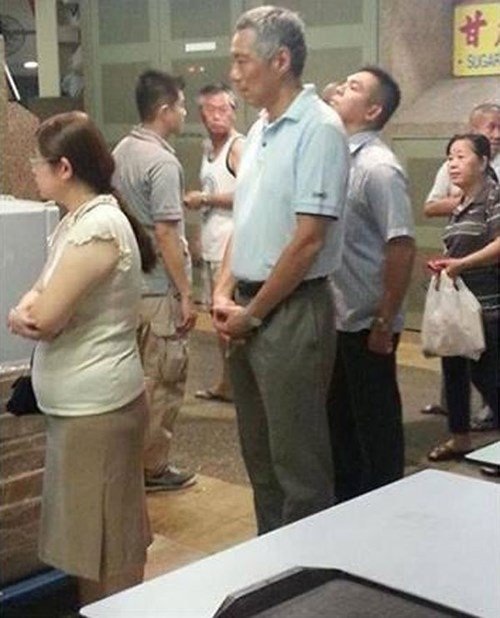 Những nguyên thủ thế giới dùng bữa tại quán bình dân - 3 Thủ tướng Lý Hiển Long (giữa) xếp hàng chờ mua cánh gà chiên mật ong.
