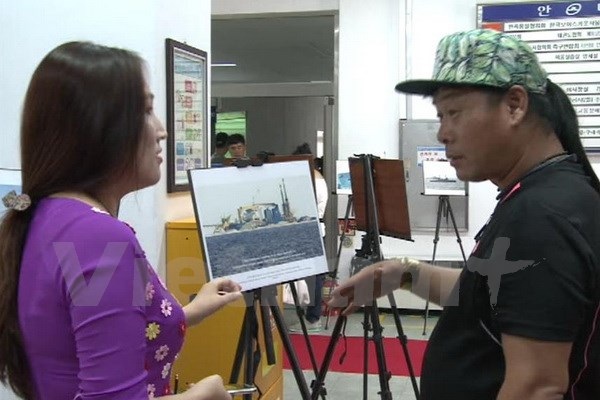 Triển lãm những hình ảnh chân thực về Biển Đông tại Hàn Quốc - 6 Một tình nguyện viên đang giới thiệu cho khách Hàn Quốc thăm quan triển lãm. (Ảnh: Phạm Duy/Vietnam+)