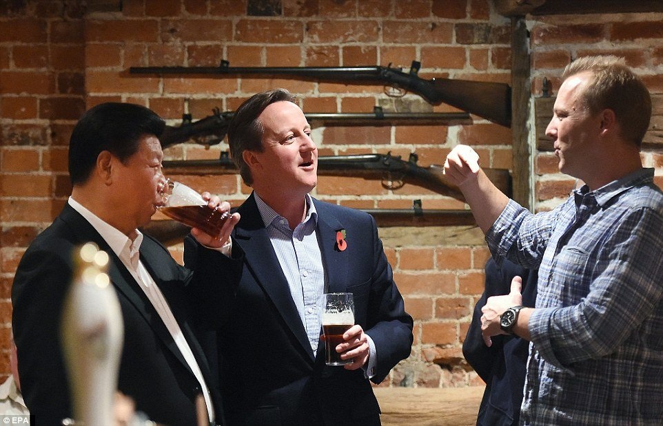 Chủ tịch Tập Cận Bình (trái) và Thủ tướng David Cameron (giữa) vừa uống bia vừa giao lưu với người dân trong một quán rượu bình dân ở thủ đô London.