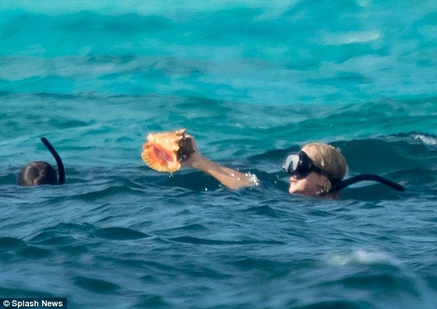 
Cô tìm được một con ốc rất đẹp dưới nước
