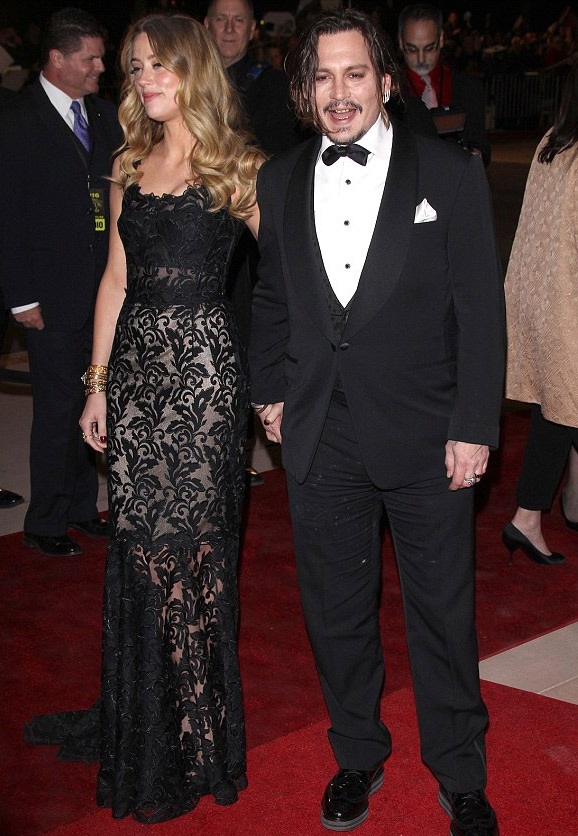 
Ngôi sao 52 tuổi nắm chặt tay vợ trẻ trên thảm đỏ.
