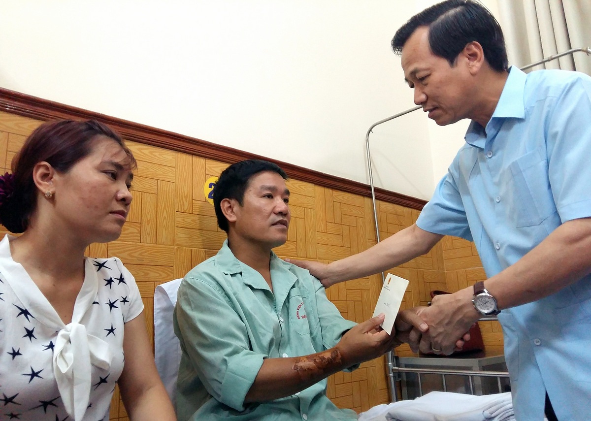 
Bộ trưởng Đào Ngọc Dung (bìa phải) hỏi thăm sức khỏe Thiếu tá, phi công Nguyễn Hữu Cường.
