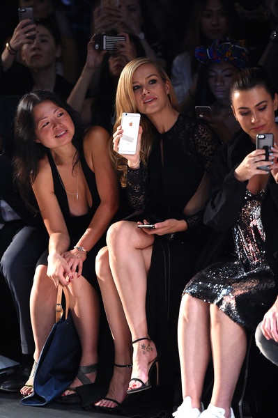 
Cô chăm chú theo dõi buổi trình diễn thời trang và còn ghi hình bằng điện thoại cá nhân.
