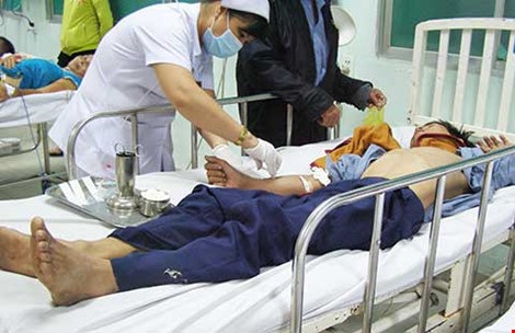 Xoay xở một hồi, nhân viên y tá mới có thể tiêm thuốc cho người thanh niên uống thuốc trừ sâu. Ảnh: TRẦN NGỌC