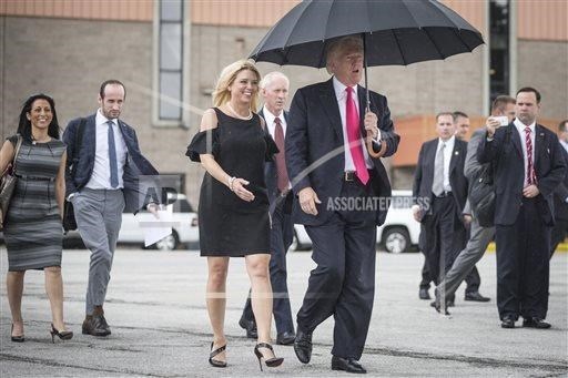 Sự khác biệt giữa Barack Obama và Donald Trump qua hai bức ảnh - 2 Ông Trump che ô để bảo vệ mái tóc của mình. (Nguồn: AP)