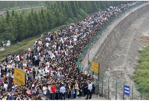 Du khách xếp hàng xem thủy triều dâng gần bờ sông Tiền Đường ở Hàng Châu, Chiết Giang. Các con sóng vọt lên mức cao nhất vào tháng 9 hàng năm.