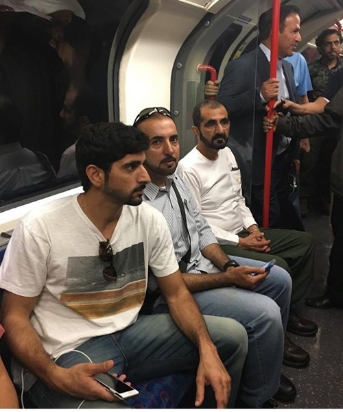 Quốc vương và thái tử Dubai giản dị đi tàu điện ngầm ở London - 2 Đoàn tùy tùng của hai người cũng giản dị đứng bên cạnh bảo vệ.
