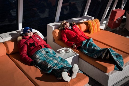 Nghỉ ngơi bên mạn tàu khi tàu đi qua Smoking Hills của Canada - nơi phiến đá dầu tự bốc cháy và đã cháy trong nhiều thế kỉ