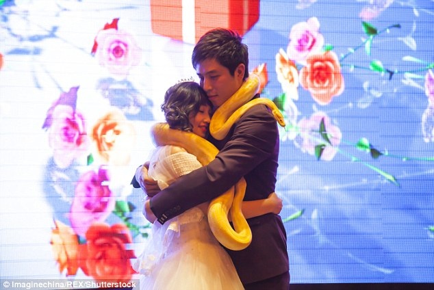 
Cặp đôi ôm nhau hạnh phúc với hai con trăn trên cổ họ.
