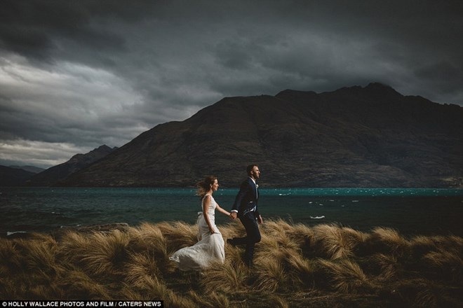 Cặp đôi chạy trên những cánh đồng ở Queenstown, New Zealand dưới nền trời đầy mây đen và gió. (Nguồn: Dailymail)