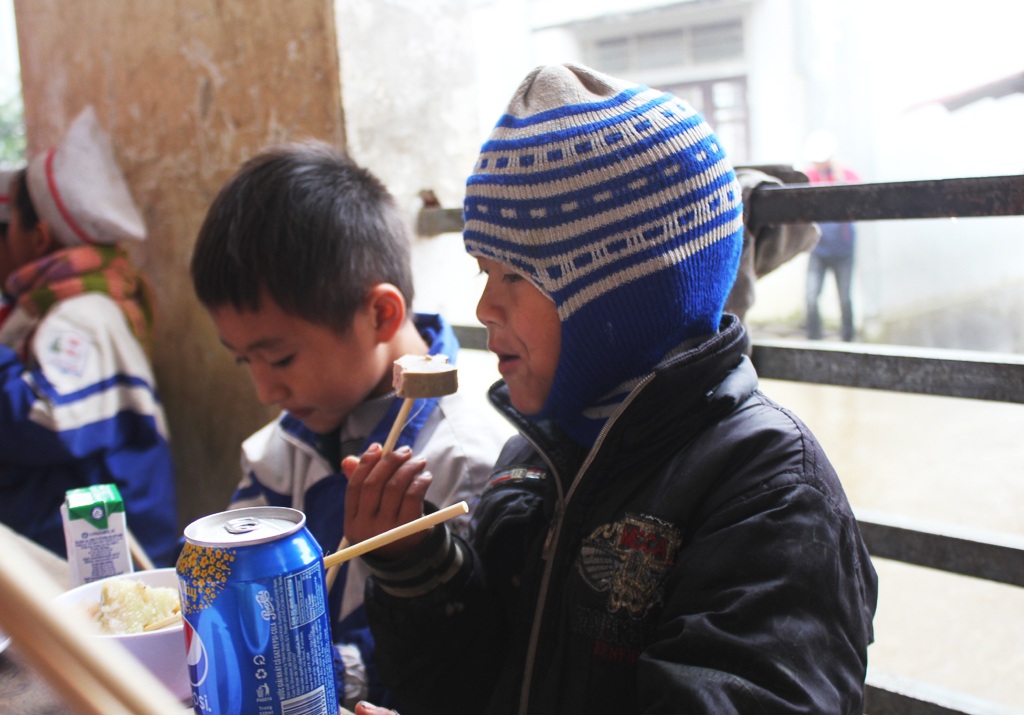 Ăn Tết sớm với học trò người H'Mông ở "cổng trời" xứ Nghệ - 6
Một cậu bé háo hức thưởng thức món giò lụa.