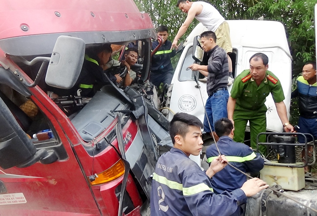 12 cảnh sát giải cứu tài xế mắc kẹt trong ca bin - 1 Tài xế Hoàng mắc kẹt trong ca bin sau khi hai xe tải đấu đầu nhau.