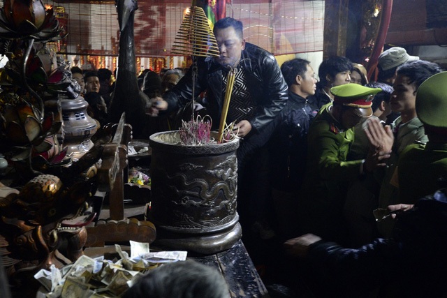 
Để giành giật lộc hay rải tiền lẻ, thắp hương trong đêm phát ấn Đền Trần, nhiều người còn leo lên cả ban thờ (Ảnh minh họa: Mạnh Thắng)
