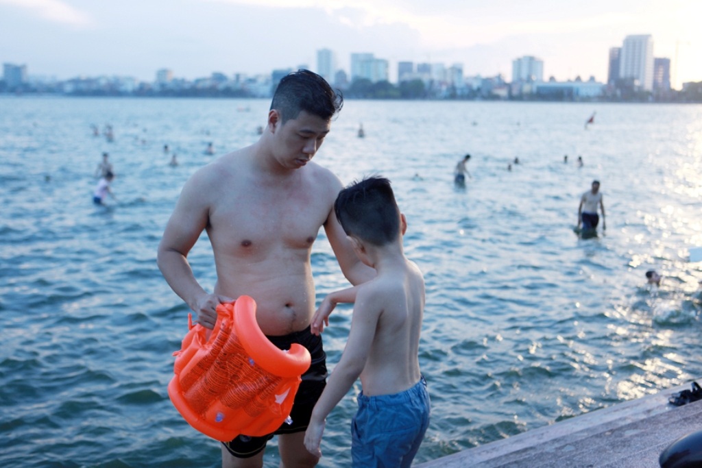 Người Hà Nội cùng thú cưng tắm hồ Tây giải nhiệt - 9
Một em nhỏ được bố mặc phao bơi trước khi xuống tắm.