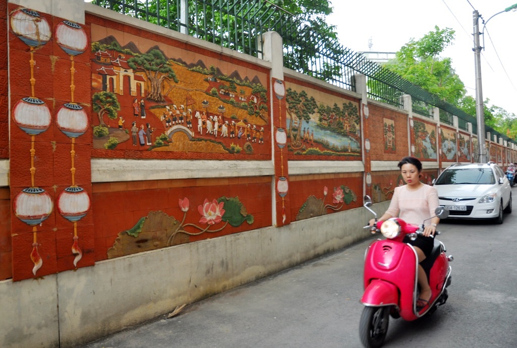 
Người đưa ra ý tưởng độc đáo này là bà Vũ Thị Bắc (57 tuổi) - một người dân sống trong ngõ. Theo đó, khu dân cư thống nhất tự đóng kinh phí, tự thiết kế các bức tranh gốm và thuê thợ về thi công. Tất cả các bức tranh đều được đồng bộ về màu sắc, kích cỡ để tạo sự nhất quán
